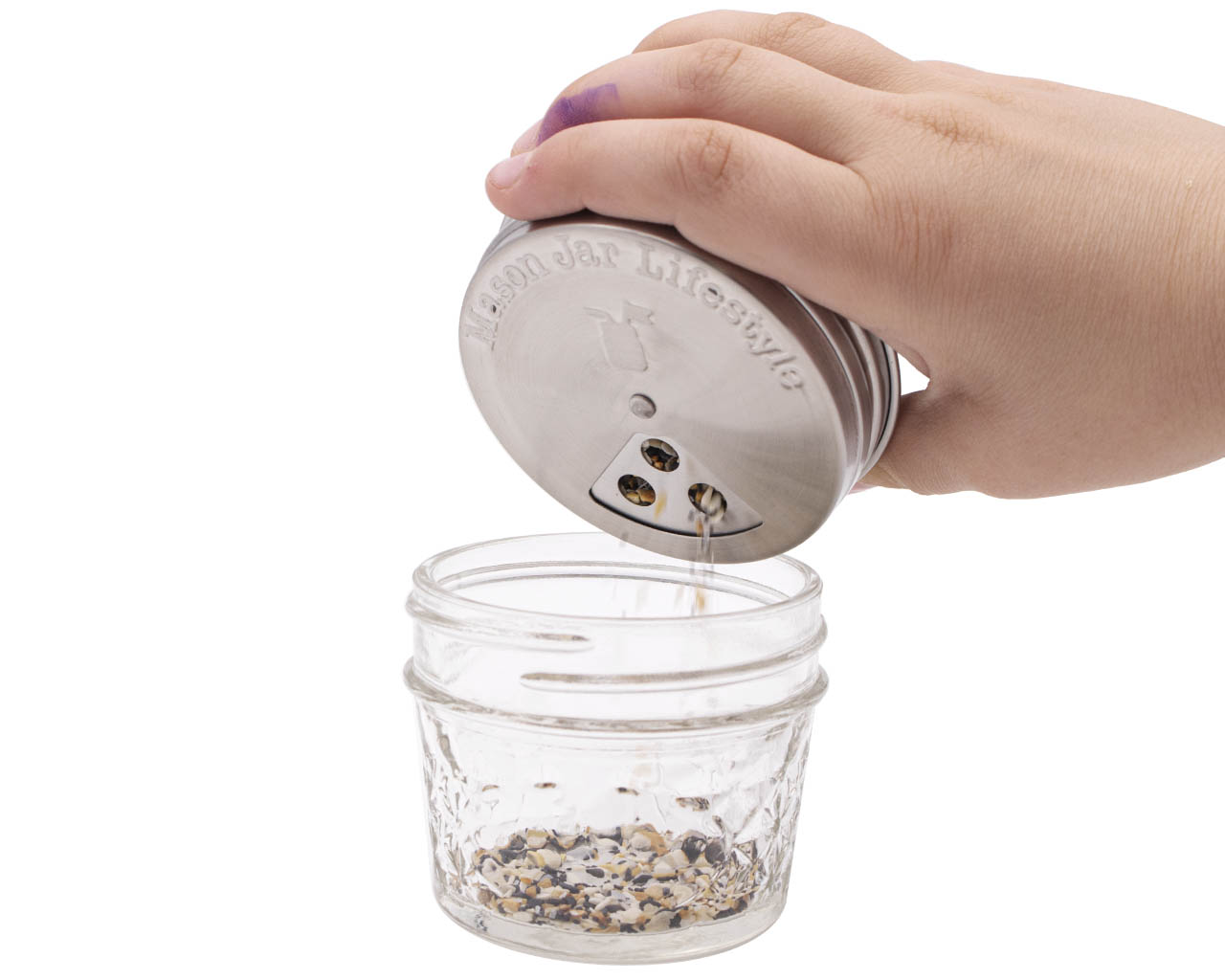 http://masonjarlifestyle.com/cdn/shop/files/mason-jar-lifestyle-regular-mouth-stainless-steel-spice-shaker-lid-large-three-hole-seed-mix-in-use.jpg?v=1695767528