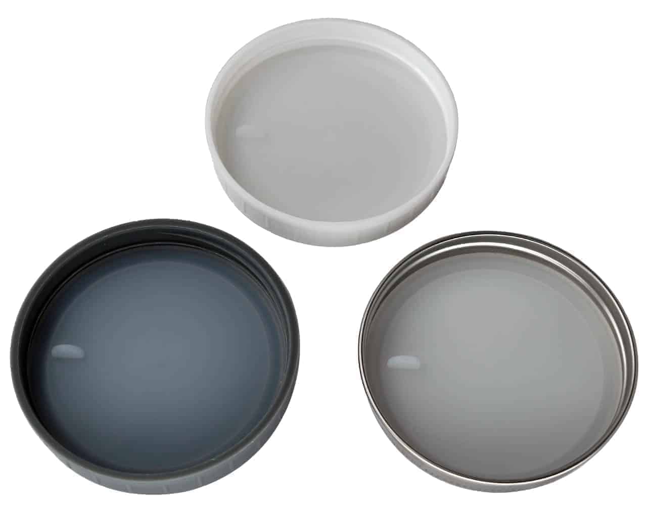Platinum silicone lid liners with tabs in three different types of regular mouth lids. Leak proof and air tight. Use with a band as a lid, or as a liner inside other lids. Fully inserted.