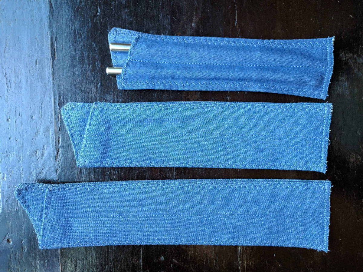 Three denim straw pouches shown in different lengths with stainless steel straws