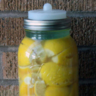 Clear silicone fermentation valve lid with Moroccan preserved lemons and tempered glass fermentation weight