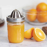 Jarware stainless steel juicing lid on wide mouth pint Mason jar with lemon juice