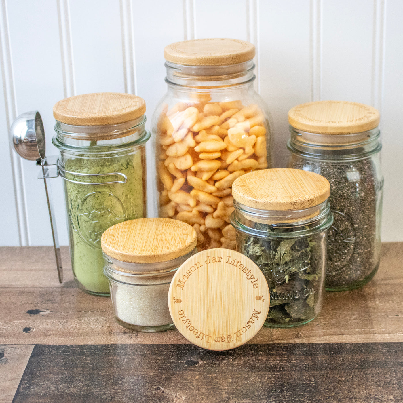 Regular mouth Mason jars with bamboo storage lids: 4oz, 8oz, 16oz, 32oz, and 64oz jars.