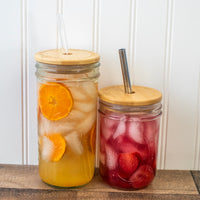 Wide Mouth straw hole lids on 24oz and 16oz Mason jars, with drinks inside.