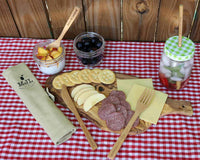 mason-jar-lifestyle-bamboo-utensil-set-roll-up-cotton-carrying-bag-fork-knife-straw-pint-jar-gingham-lid-cutting-board-cheese-apples-salami-crackers