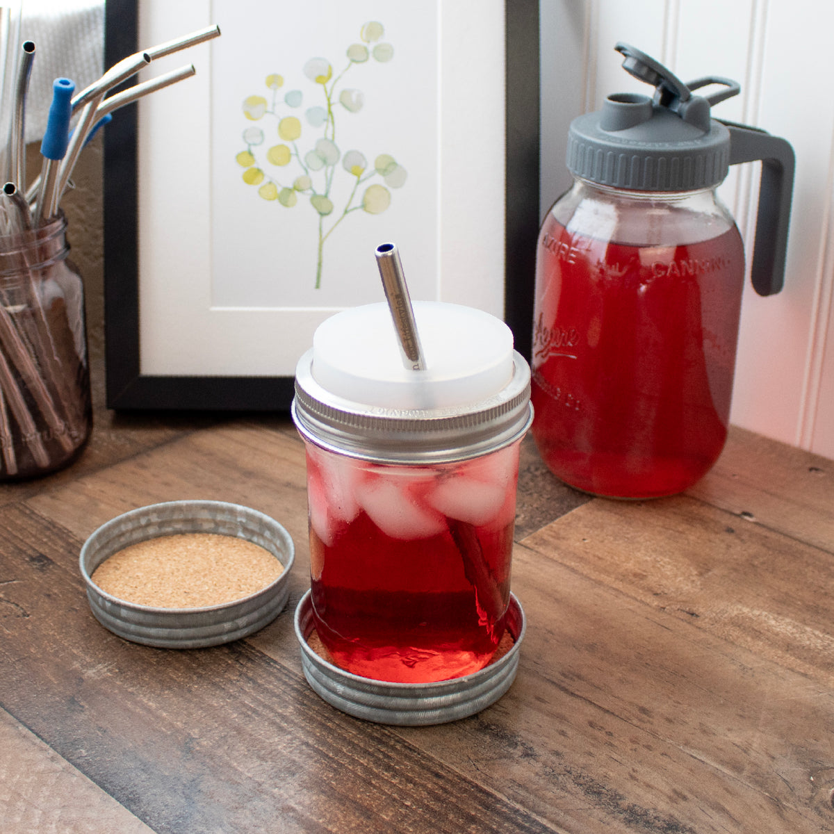 A wide mouth pint Mason jar on one of the coasters, next to another. A quart Mason jar to the side, as it does not fit.