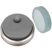 Up close on a fermentation weight, which has a raised design that says "Mason Jar Lifestyle".