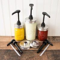 A group photo of 3 Mason jars with the food grade pumps, and 2 sets of the food grade pump, in regular and wide mouth sizes.