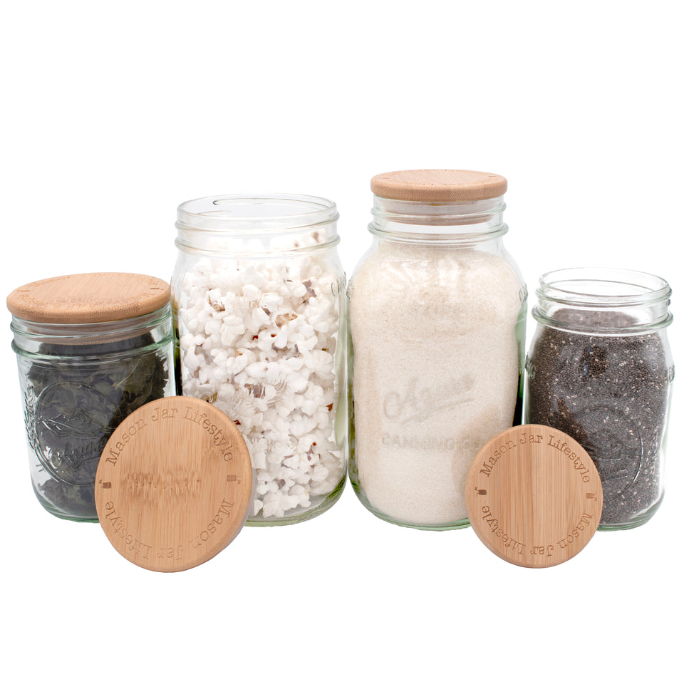 Bamboo storage lids for Mason jars, regular mouth and wide mouth, on a couple different sizes of Mason jars.