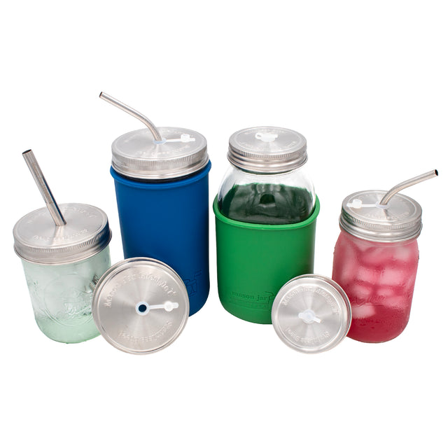 Regular mouth and wide mouth Mason jars with stainless steel straw lids on them and next to them. Notably two have thin bent straws in them, with the plug in, and one has a safer straw in it, without the plug.