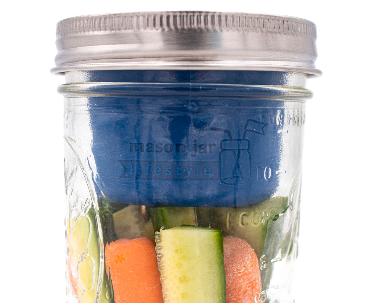 wide mouth deep blue silicone divider cup with stainless steel storage lid on 16oz wide mouth pint jar with carrots and veggies