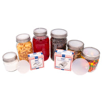 A bunch of Mason jars with silicone lid liners, and stainless steel bands (sold separately), containing different food items. In front, there are two sets of the ten packs in their box packaging.