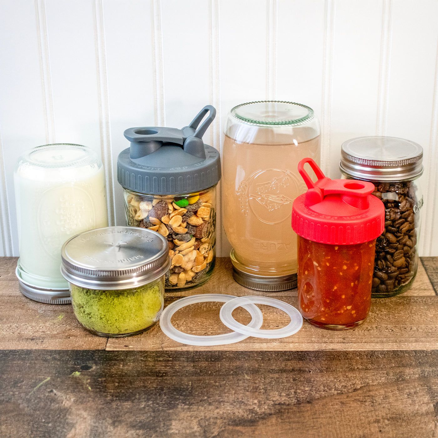 Wide mouth and regular mouth silicone sealing rings, amongst a bunch of jars that have lids with sealing rings in them.