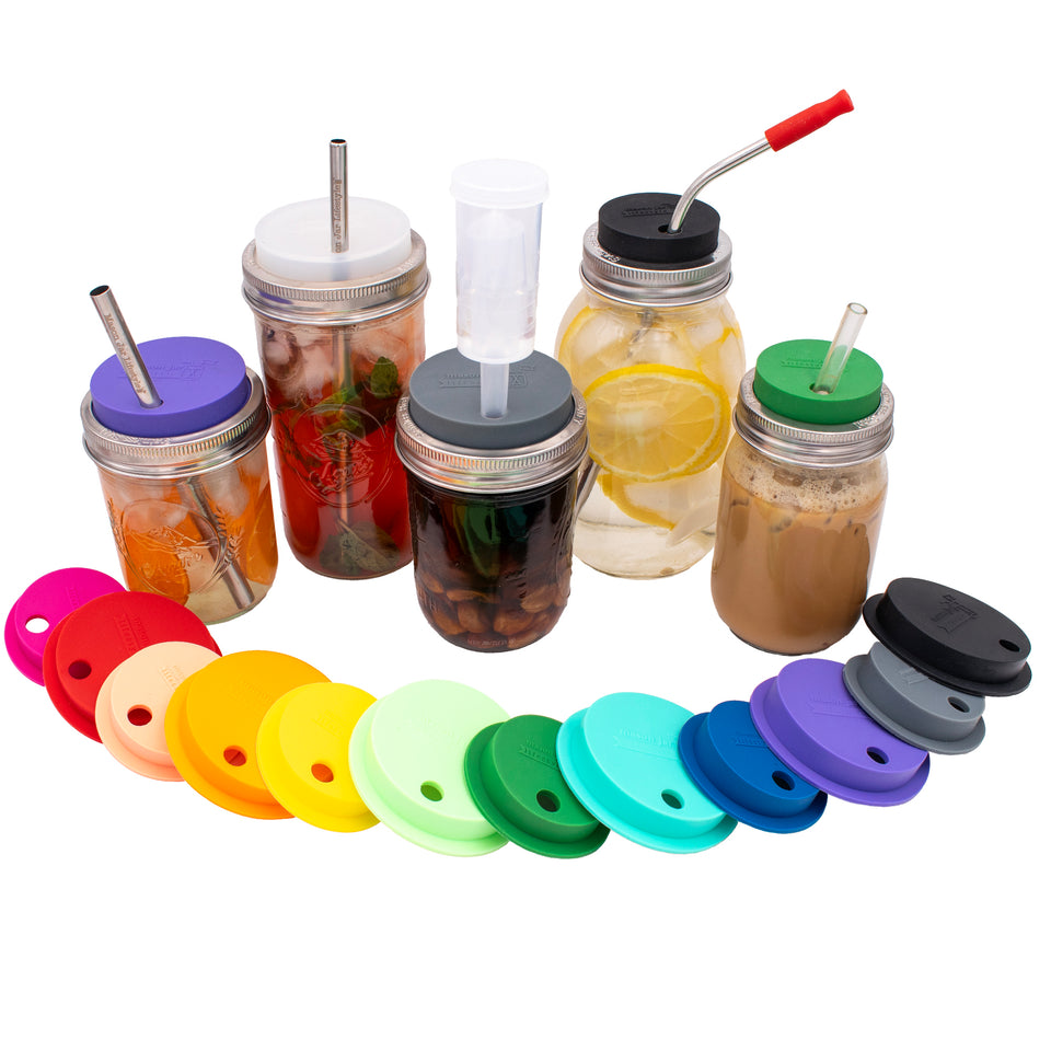 Regular and wide mouth silicone straw hole lids laid out in all colors and sizes available, and on different sized jars with accessories.