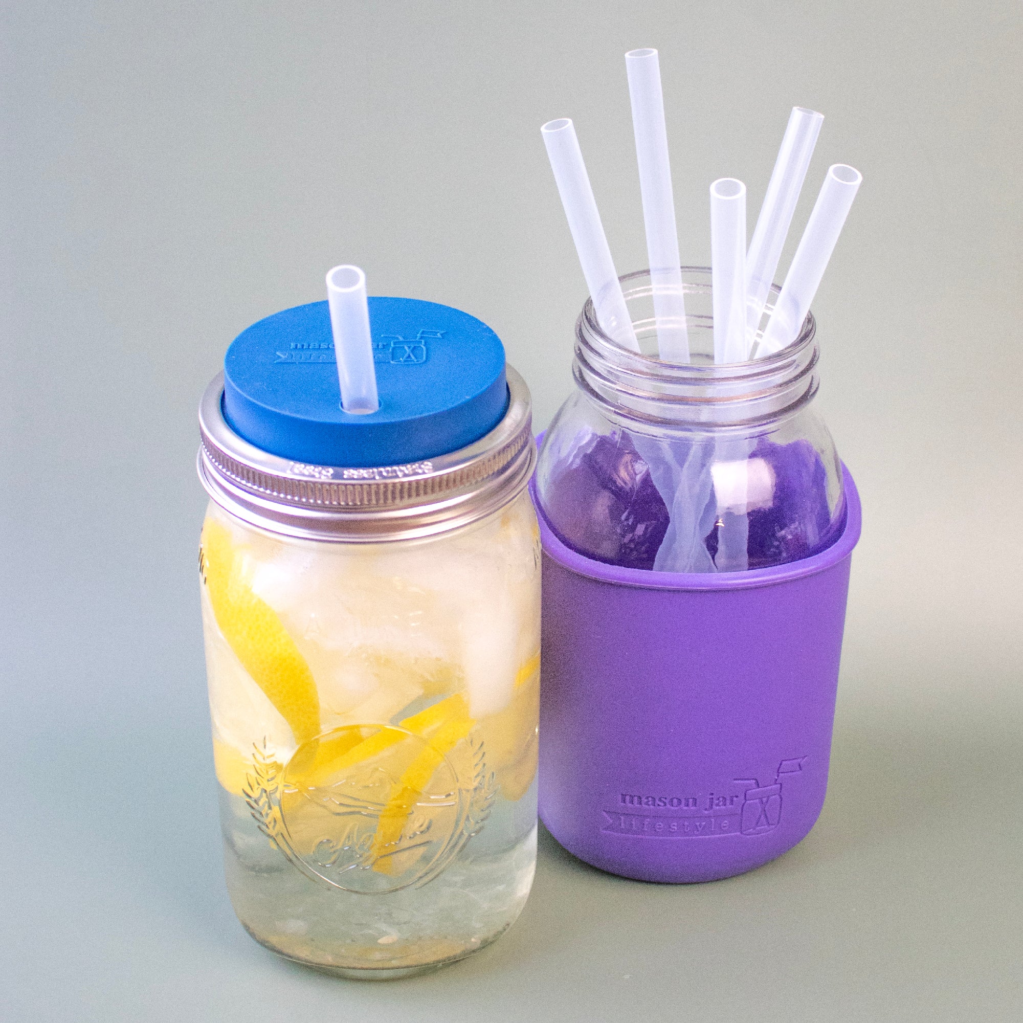 Silicone straws in 32oz Quart Mason jars, against a green background to show that the material is translucent.