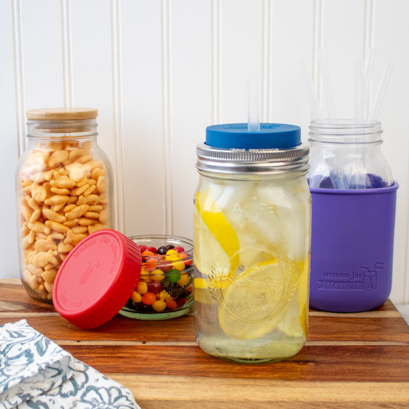 Mason jars with silicone straws, and plastic storage lids, and bamboo storage lids.