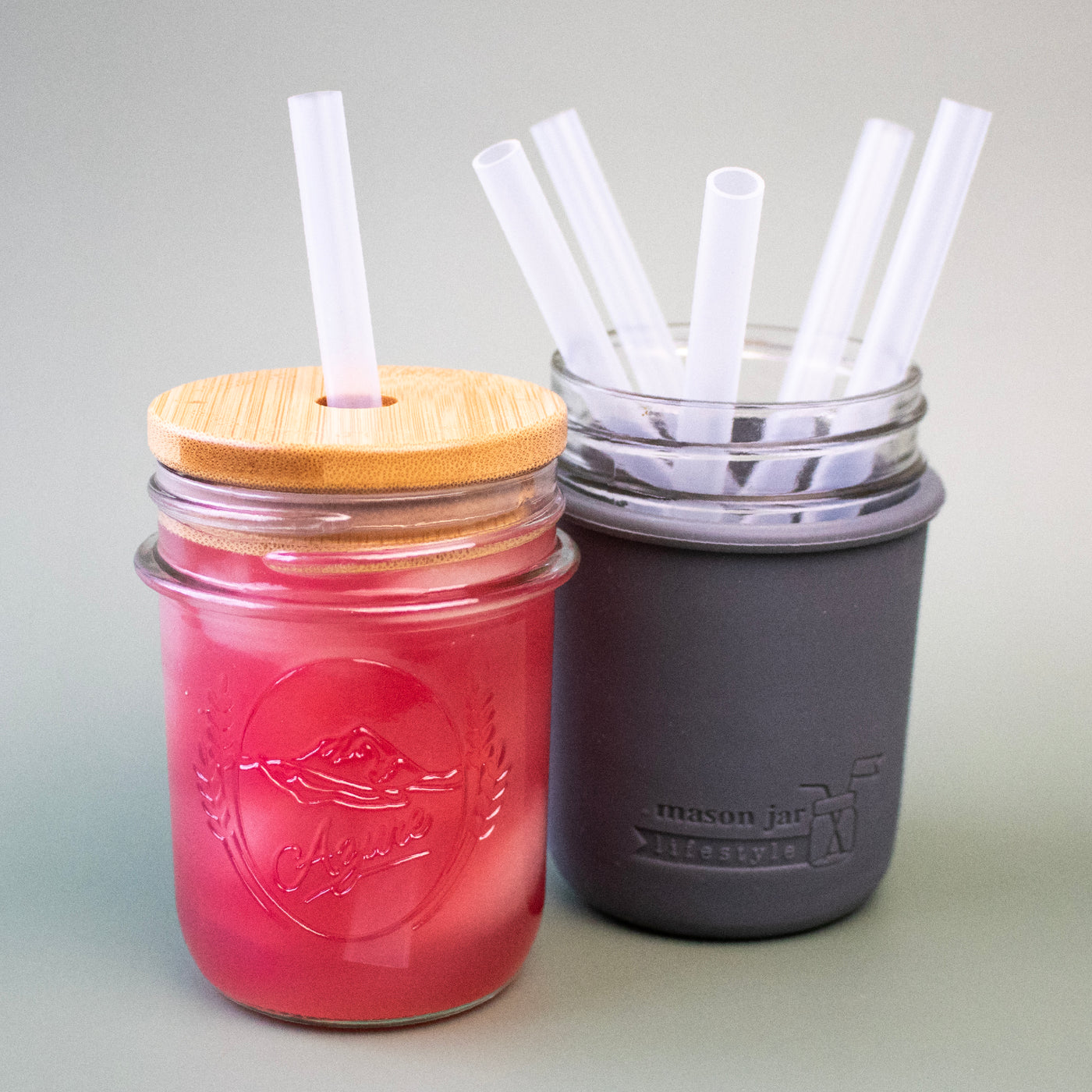 Silicone straws in regular mouth 8oz Mason jars, against a green background to show that the material is translucent.
