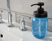 Oil rubbed bronze soap pump dispenser lid kit on blue Ball Mason pint jar on sink