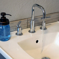 Oil rubbed bronze soap pump dispenser lid kit on blue Ball Mason pint jar on sink with running water