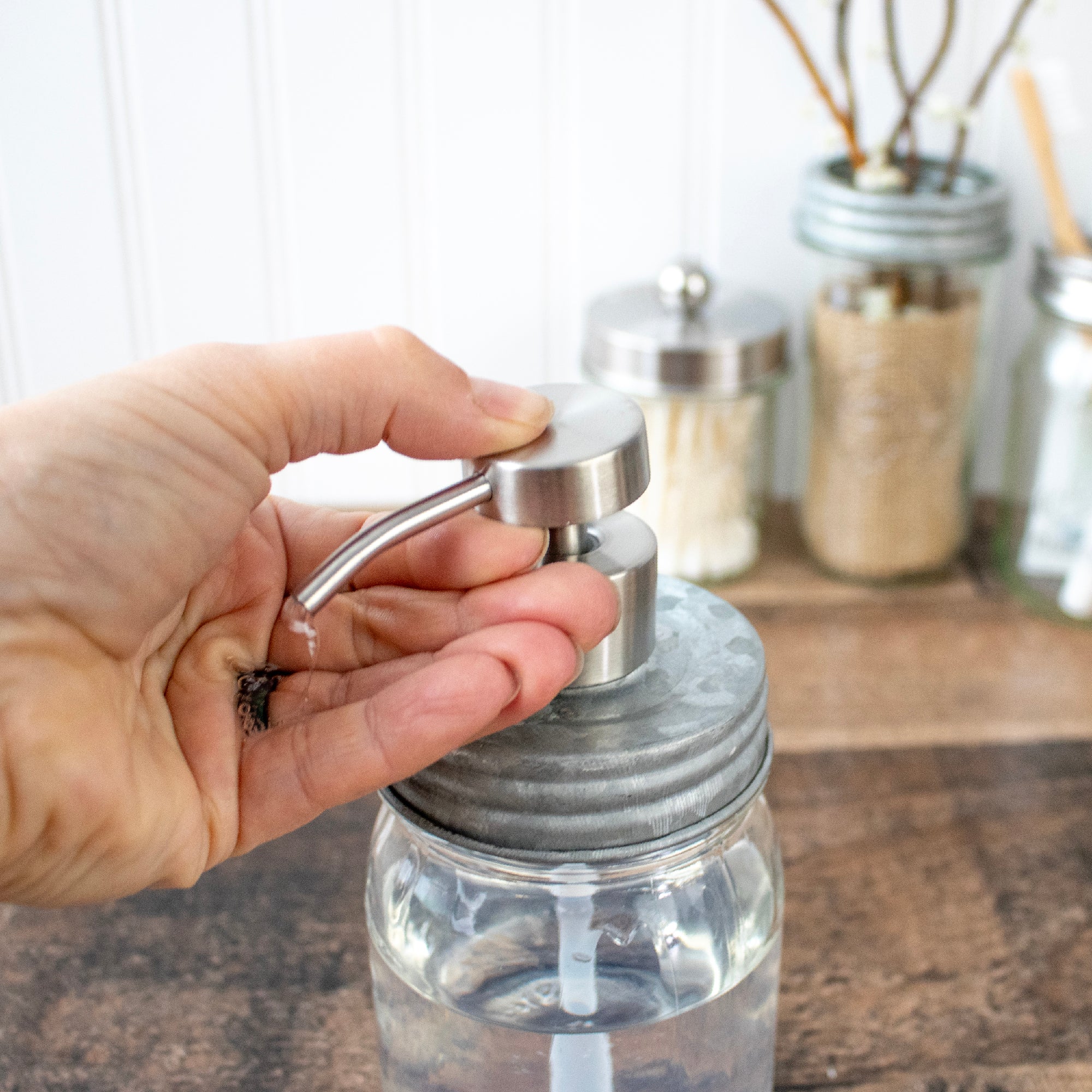 Pressing down with one hand on a soap pump.