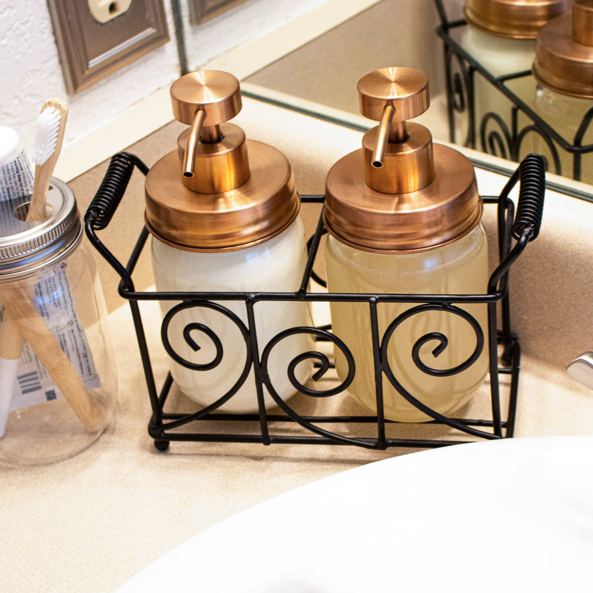 Rose gold soap pumps on pint Mason jars in a swirl caddy.
