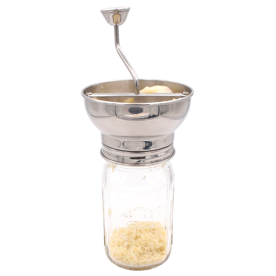 Stainless steel food mill on a wide mouth Mason jar.