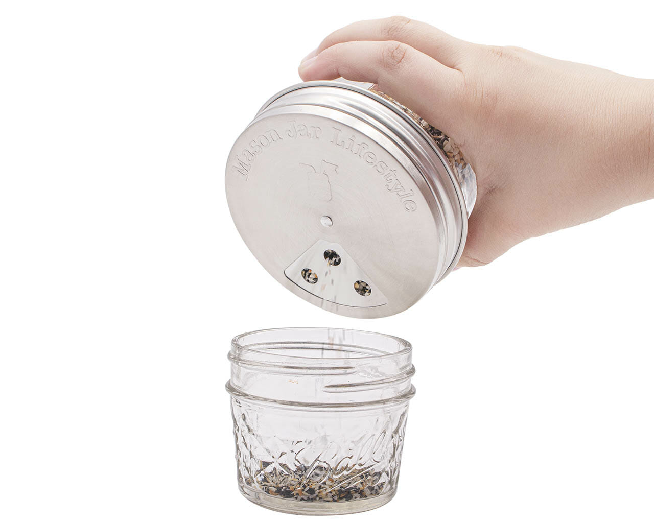 https://masonjarlifestyle.com/cdn/shop/files/mason-jar-lifestyle-wide-mouth-stainless-steel-spice-shaker-lid-large-three-hole-seed-mix-in-use.jpg?v=1695767631&width=1280