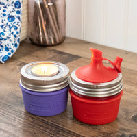 Ultra Violet and Cherry Red silicone sleeves on 4oz jelly Mason jars. One with a tea light candle insert and one with a oil cruet.