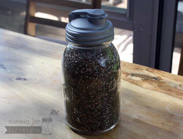 Silver Regular Mouth reCAP pour spout lid on a Mason jar filled with a smoothie seed mixture.