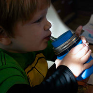 Boy drinking from half pint 8oz Mason jar with silicone straw, sleeve, and lid