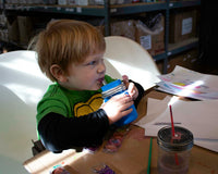 Boy painting and drinking from half pint 8oz Mason jar with silicone straw, sleeve, and lid