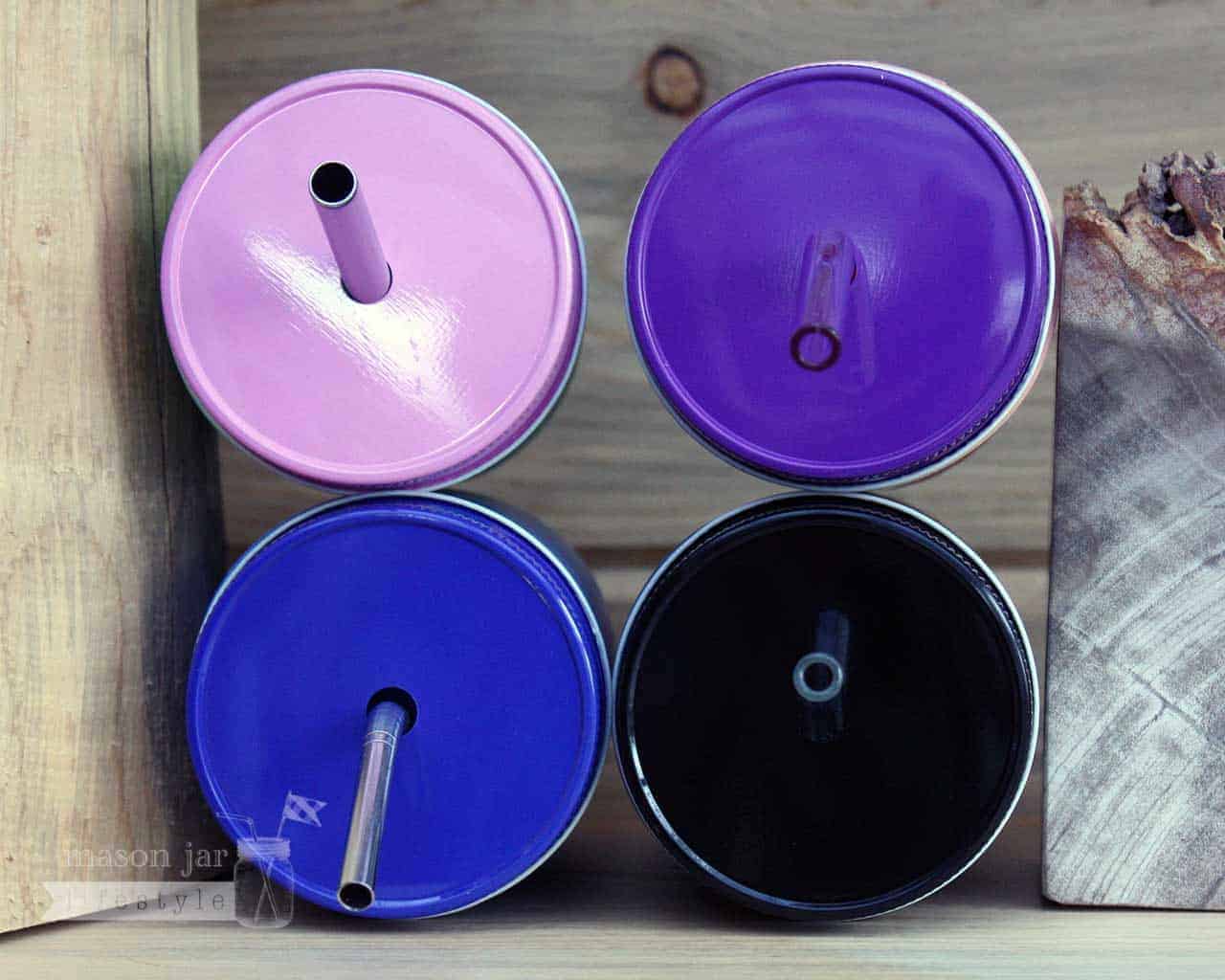 Solid color straw hole tumbler lids on regular mouth half pint Mason jars with reusable straws