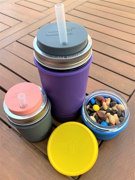 Mason jars at the pool, on the go, or on a road trip using silicone sleeve / jacket, straw hole lids, plastic storage lid, and silicone straws for drinks and snacks like trail mix