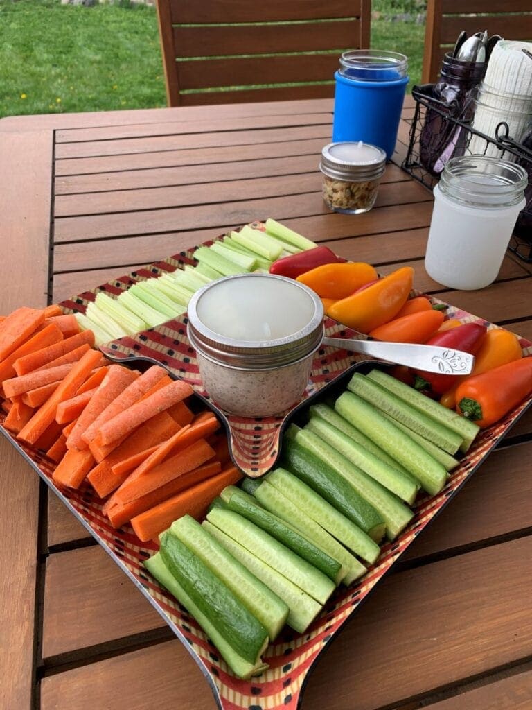 Ideas for outdoor entertaining with Mason jars including carrots, celery, mini bell peppers, and cucumbers with homemade ranch dip stored in a 8 oz wide mouth half pint Mason jar and Mason Jar Lifestyle silicone lid liner and stainless steel band.