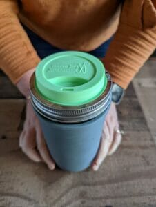 mason-jar-lifestyle-pint-and-half-gray-silcone-sleeve-green-silicone-drinking-lid-lifestyle-with-hands
